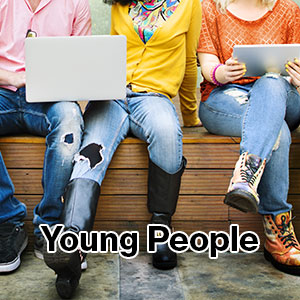 A photo of young people chatting and looking at their laptops